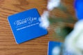 Blue celebration beer mat with silver text on a wooden table at